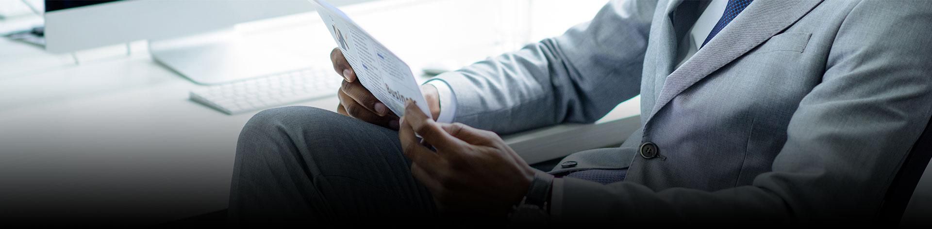 Business professional reviewing financial reports and company documents in a modern office environment
