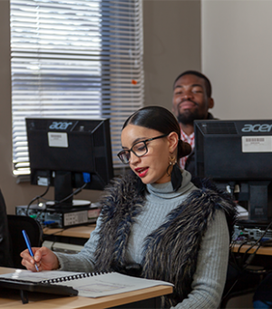 Students participating in a computer skills training class in a modern classroom environment