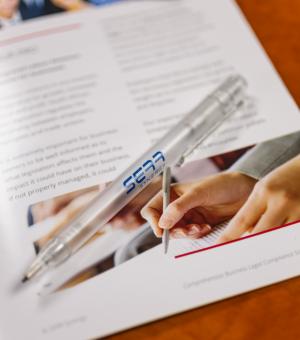 Corporate branded pen and business documents on a professional office desk