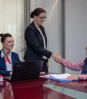 Professional business consultation meeting with client handshake and office teamwork