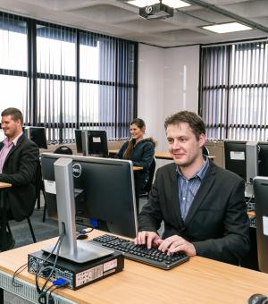 Modern business training facility with professionals working on desktop computers
