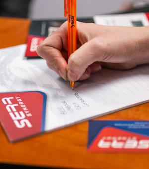 Close-up of branded company pen and training workbook during a business seminar