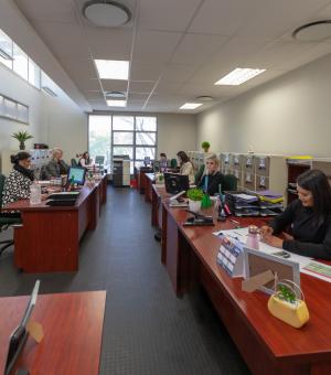 Open-plan office workspace with administrative staff at desks